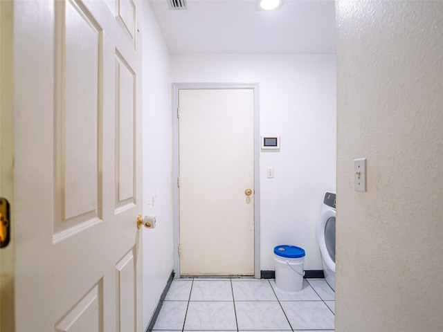 washroom with washer / dryer and light tile patterned flooring