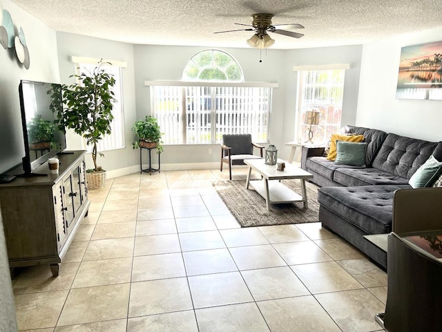 living room featuring ceiling fan, light tile patterned floors, and a healthy amount of sunlight