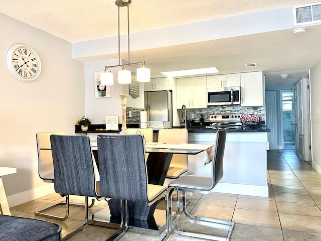 dining room with light tile patterned floors and a textured ceiling