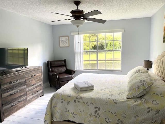 bedroom with ceiling fan and a textured ceiling