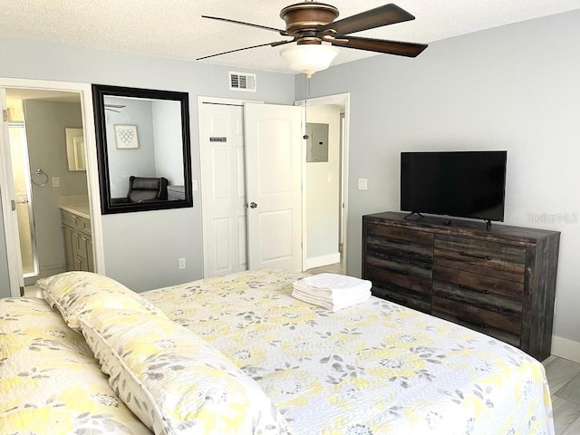 bedroom with a textured ceiling, ceiling fan, connected bathroom, electric panel, and a closet