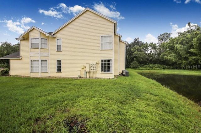 rear view of house with a lawn and cooling unit