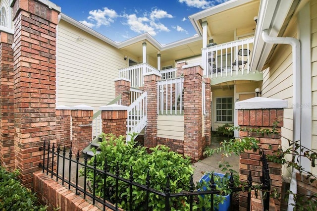 view of exterior entry with a balcony