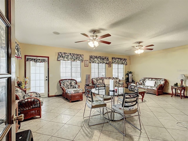 dining area with ceiling fan, light tile patterned floors, and a textured ceiling