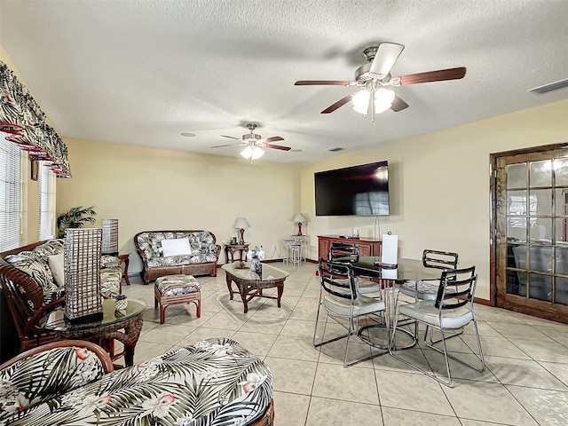 tiled living room featuring a textured ceiling and ceiling fan