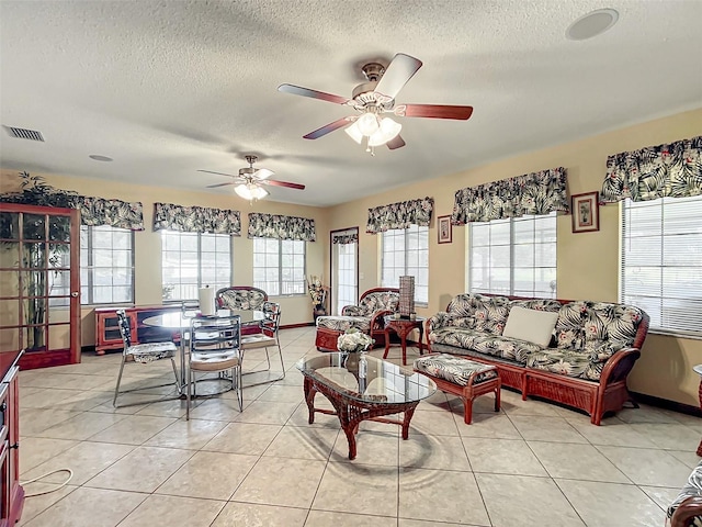 tiled living room featuring a textured ceiling and ceiling fan