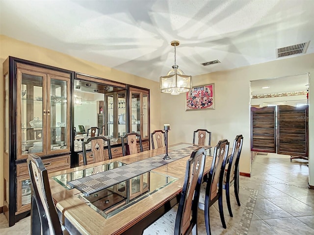 dining area featuring a chandelier and light tile patterned flooring