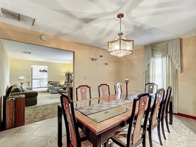 carpeted dining area with a notable chandelier