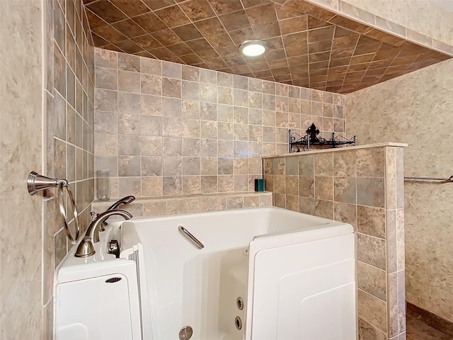 bathroom featuring a tub and tile walls