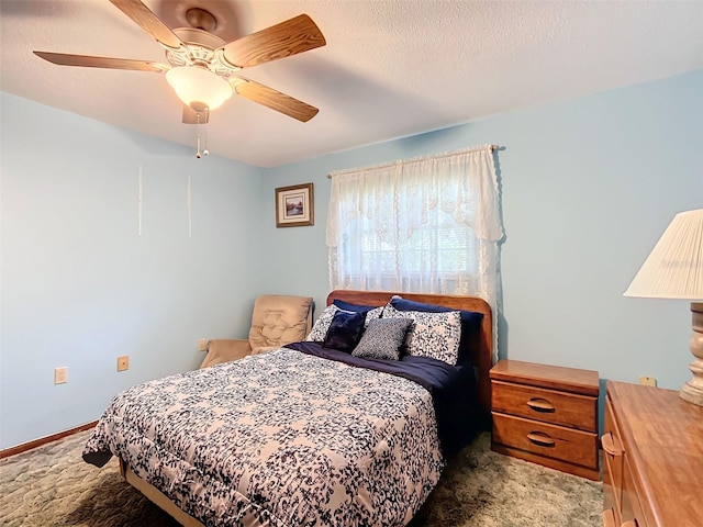 carpeted bedroom with ceiling fan and a textured ceiling