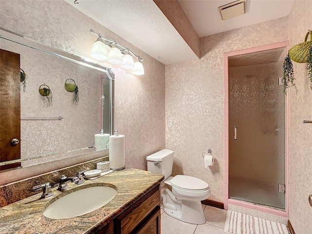 bathroom featuring toilet, vanity, tile patterned floors, and a shower with door