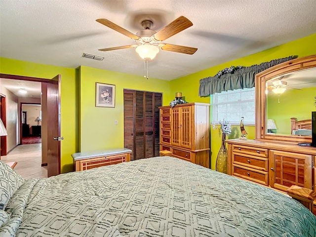 bedroom featuring ceiling fan, a closet, and a textured ceiling