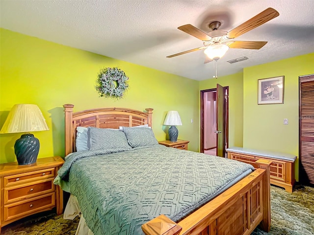 bedroom featuring carpet, ceiling fan, and a textured ceiling