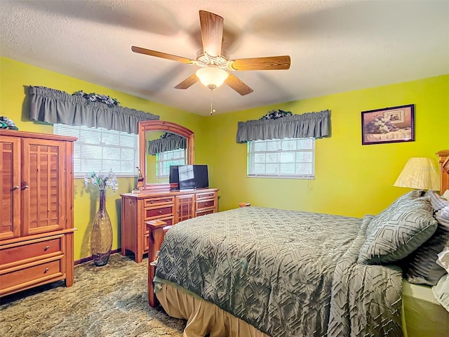 bedroom with carpet, ceiling fan, a textured ceiling, and multiple windows