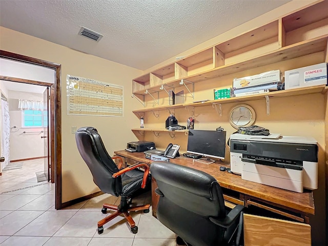 home office featuring light tile patterned flooring and a textured ceiling