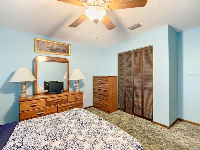 bedroom featuring a textured ceiling, ceiling fan, light carpet, and a closet