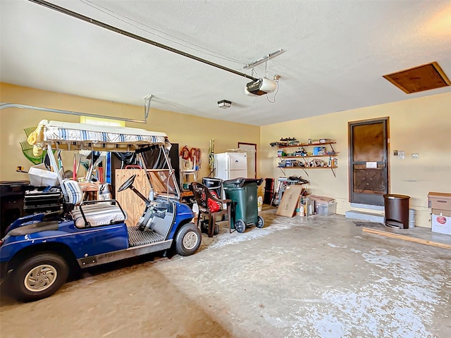 garage with white refrigerator and a garage door opener