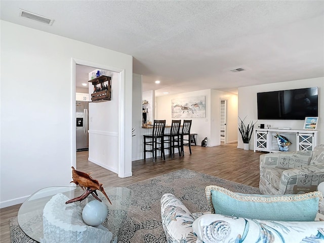 living room featuring a textured ceiling and dark wood-type flooring