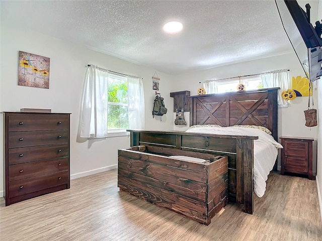 bedroom featuring a textured ceiling and light wood-type flooring