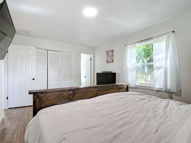 bedroom featuring light wood-type flooring and a closet