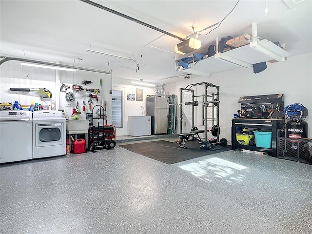 garage featuring stainless steel fridge, independent washer and dryer, a garage door opener, and white fridge