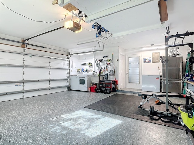 garage featuring washer and clothes dryer, stainless steel refrigerator, and a garage door opener