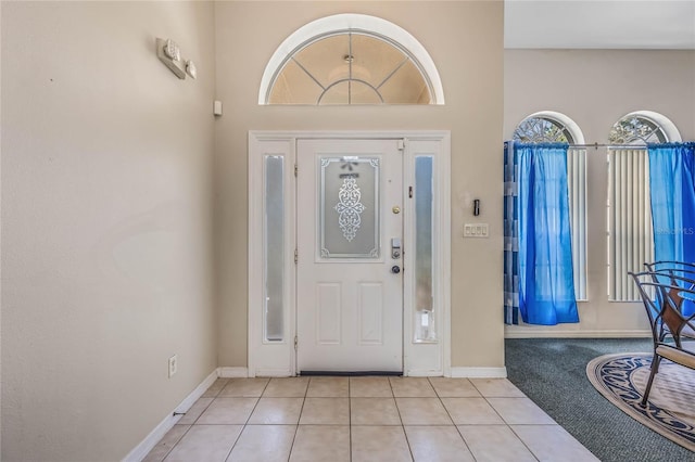 tiled foyer entrance with a towering ceiling