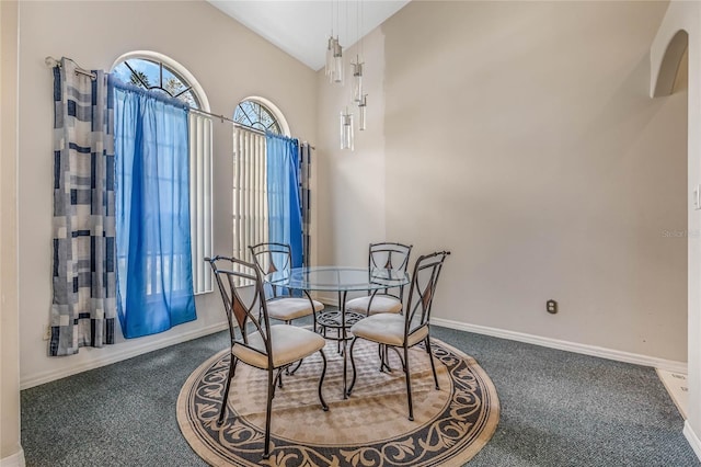 carpeted dining room with lofted ceiling