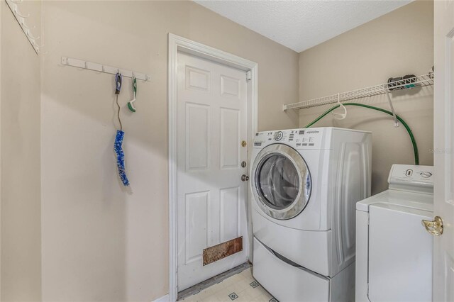 washroom with separate washer and dryer and a textured ceiling