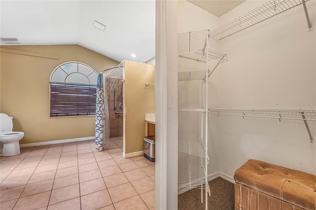 walk in closet featuring vaulted ceiling and light tile patterned floors