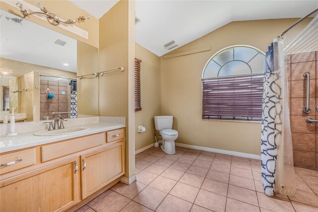 bathroom with tile patterned flooring, vanity, toilet, and vaulted ceiling