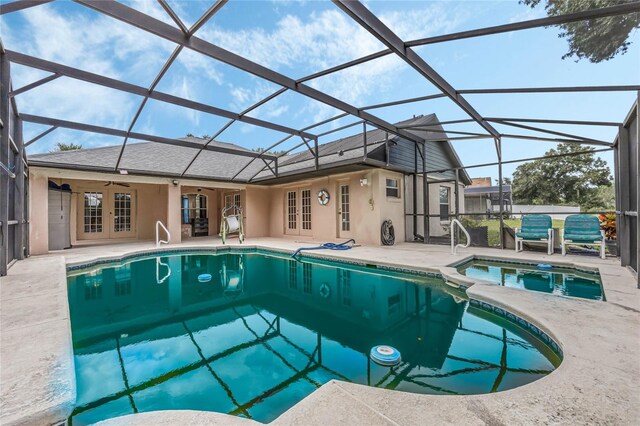 view of pool with a lanai, ceiling fan, french doors, and a patio area