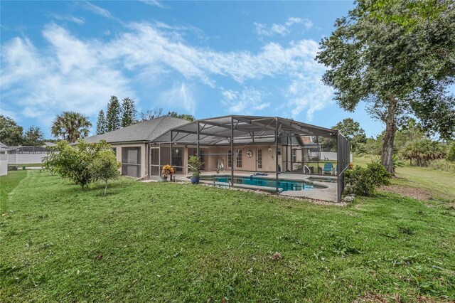 back of property featuring a patio, a yard, and a lanai