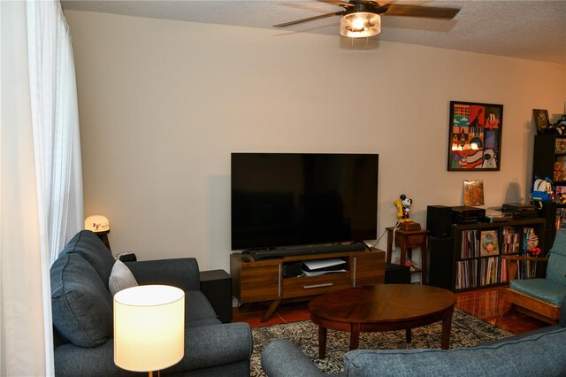 living room with a textured ceiling and ceiling fan