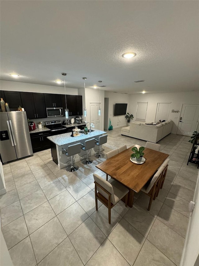 tiled dining room featuring a textured ceiling and sink