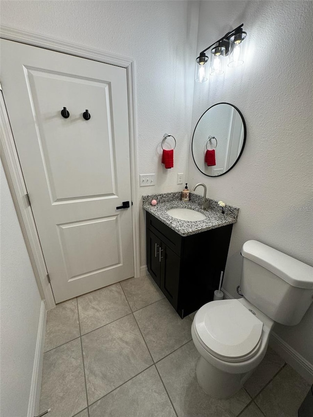 bathroom featuring vanity, tile patterned flooring, and toilet