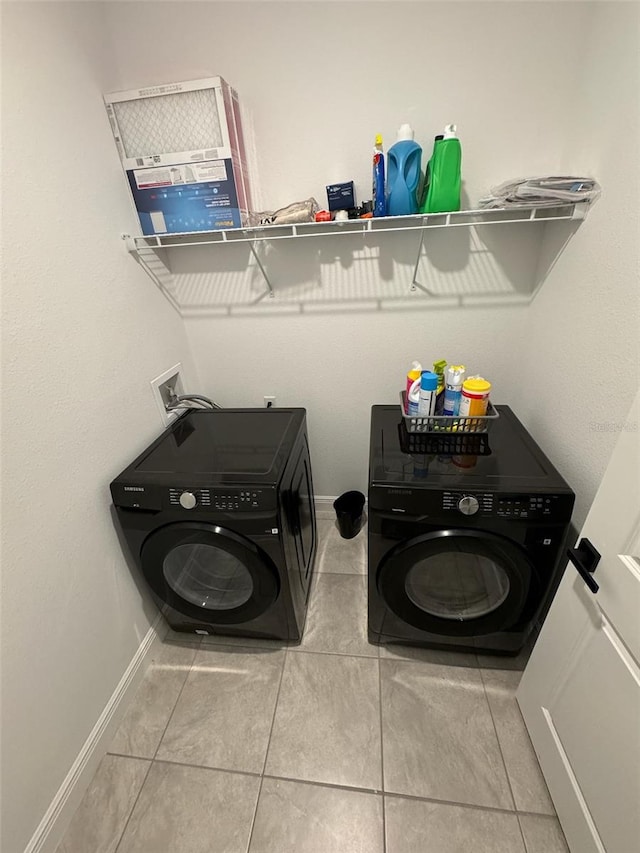 laundry area featuring light tile patterned flooring and washing machine and clothes dryer