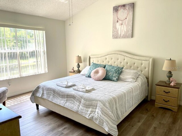 bedroom featuring a textured ceiling and dark wood-type flooring