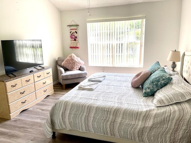 bedroom with light hardwood / wood-style flooring and a textured ceiling