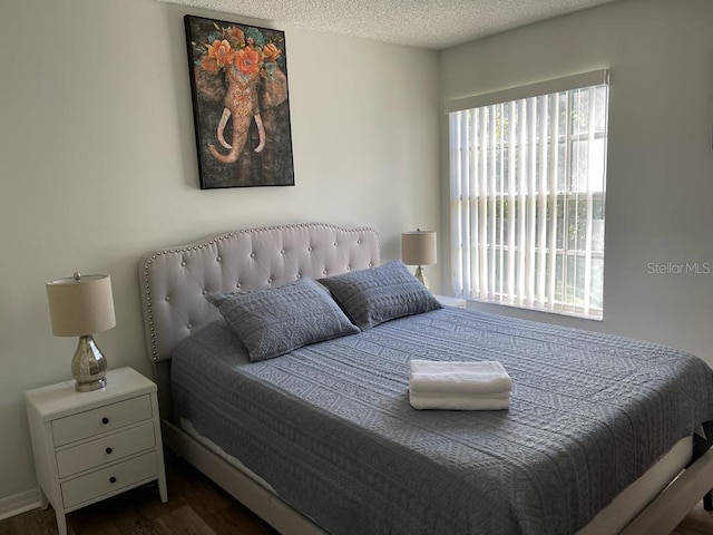 bedroom with dark hardwood / wood-style flooring and a textured ceiling