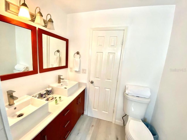 bathroom featuring vanity, hardwood / wood-style flooring, and toilet