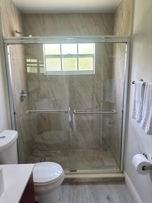 bathroom with vanity, toilet, wood-type flooring, and walk in shower