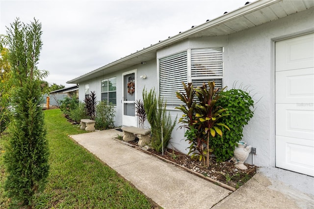 property entrance with a lawn