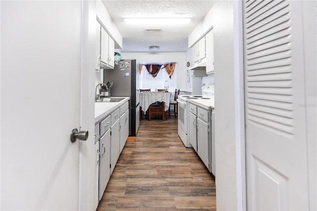 kitchen featuring a textured ceiling, dark hardwood / wood-style floors, sink, white cabinetry, and white electric stove