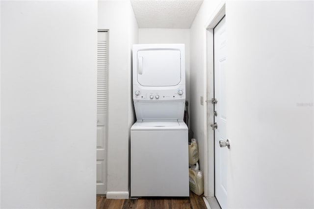 washroom featuring dark hardwood / wood-style flooring, a textured ceiling, and stacked washer and clothes dryer