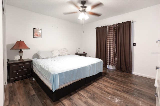 bedroom with ceiling fan, dark hardwood / wood-style floors, and a textured ceiling