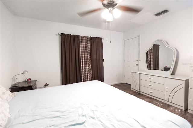 bedroom featuring ceiling fan, a textured ceiling, and dark hardwood / wood-style floors