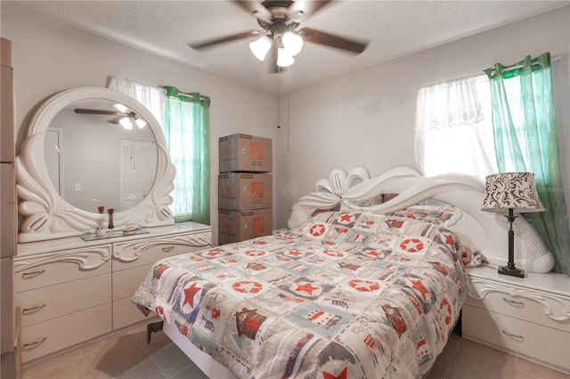 tiled bedroom featuring ceiling fan and a textured ceiling