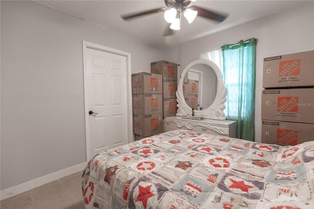 bedroom featuring ceiling fan, a textured ceiling, and light tile patterned flooring