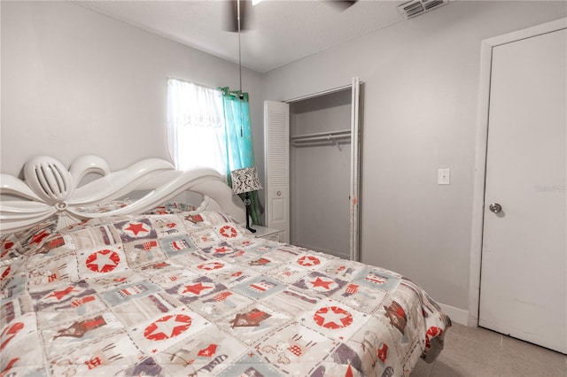 tiled bedroom with a closet, ceiling fan, and a textured ceiling